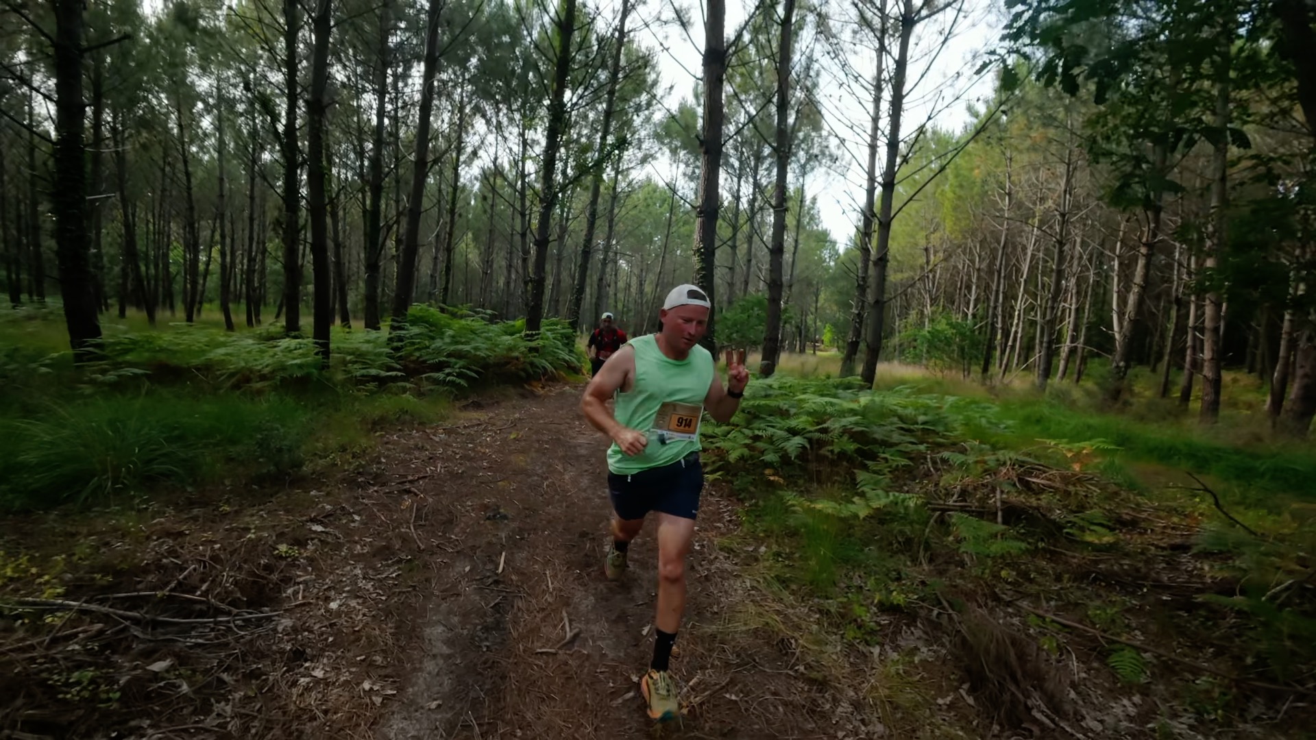 Coureur en débardeur vert progresse dans la forêt de pins
