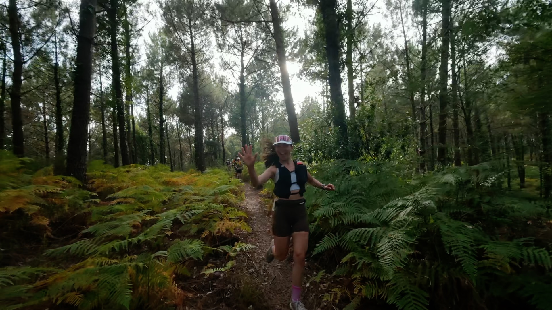 Coureuse souriante saluant dans la forêt landaise