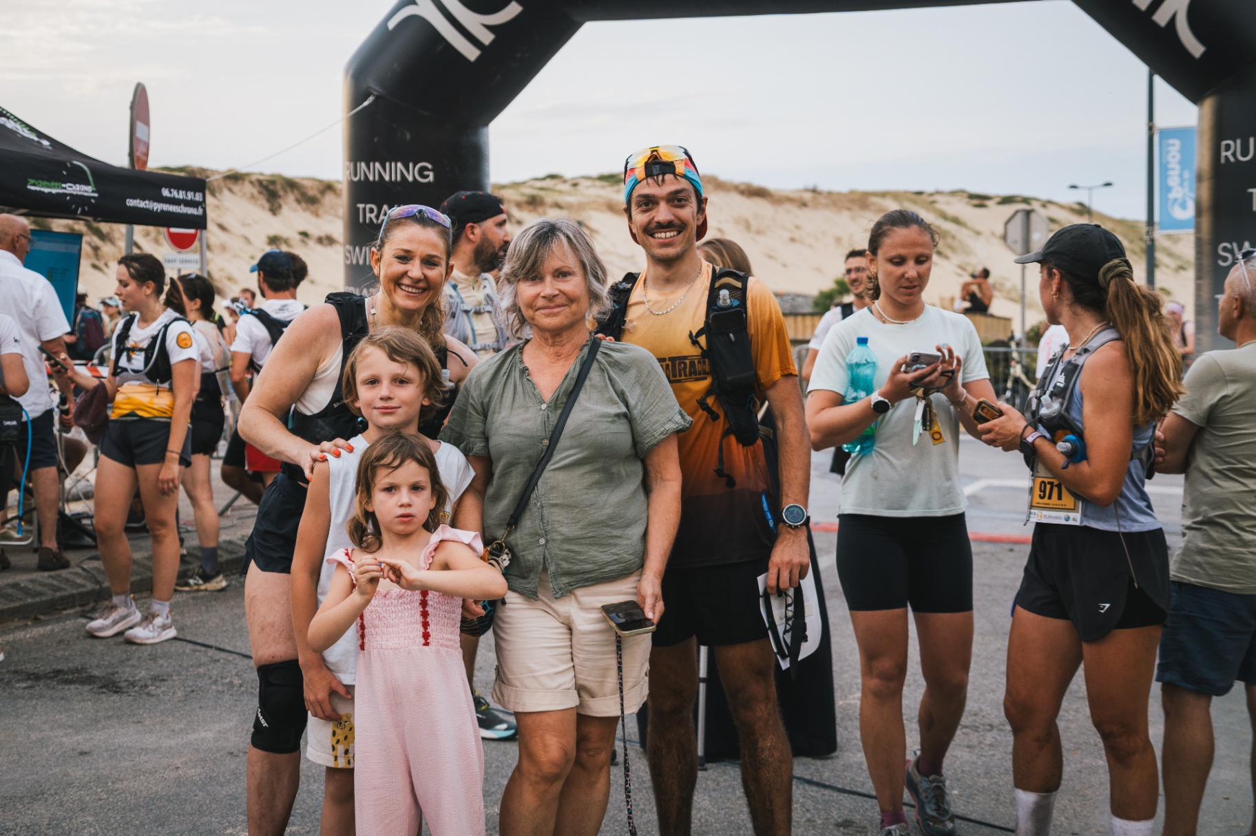 Famille et enfants sous l'arche d'arrivée devant la dune