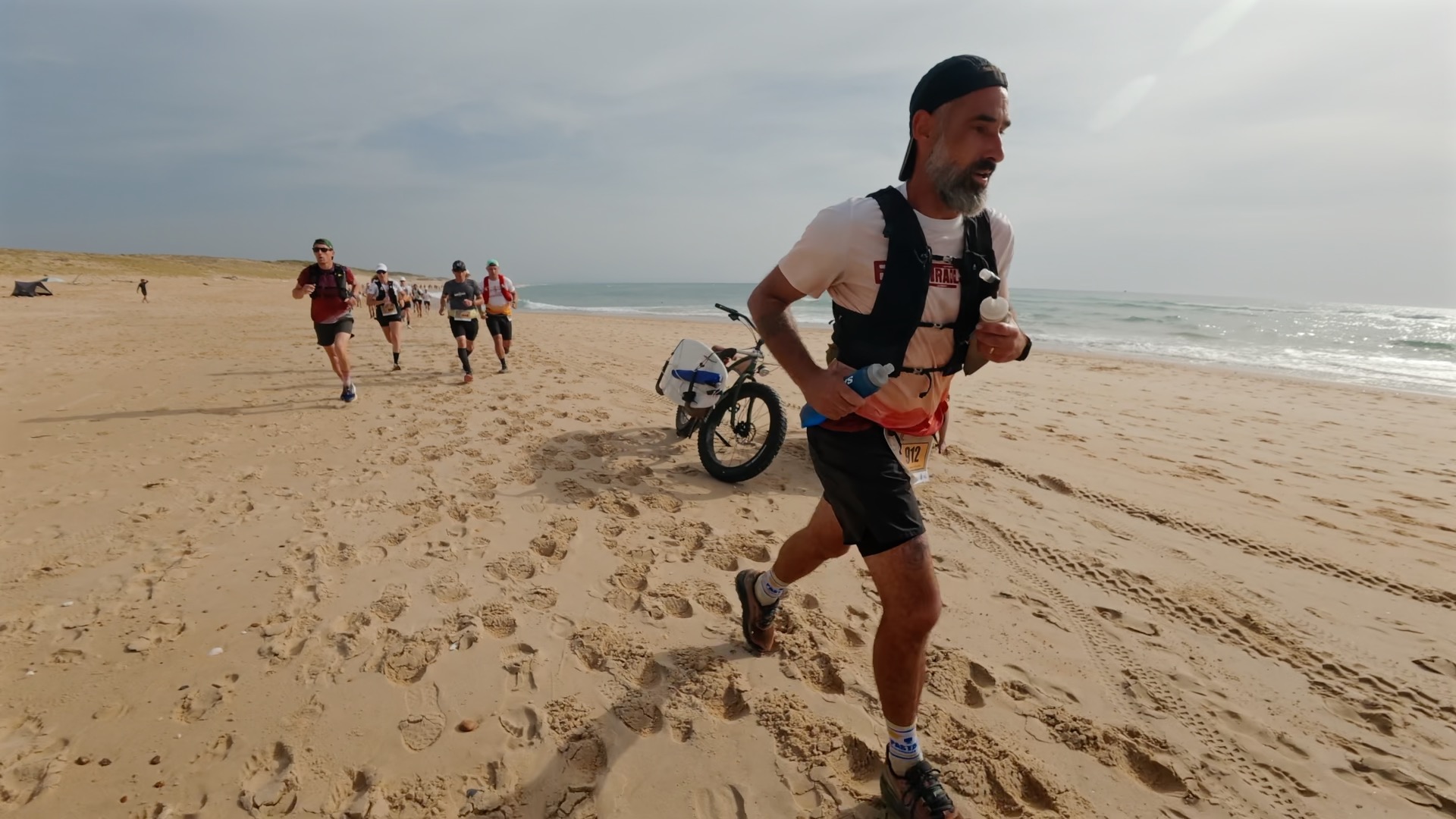 Coureur barbu en action sur la plage face à l'océan
