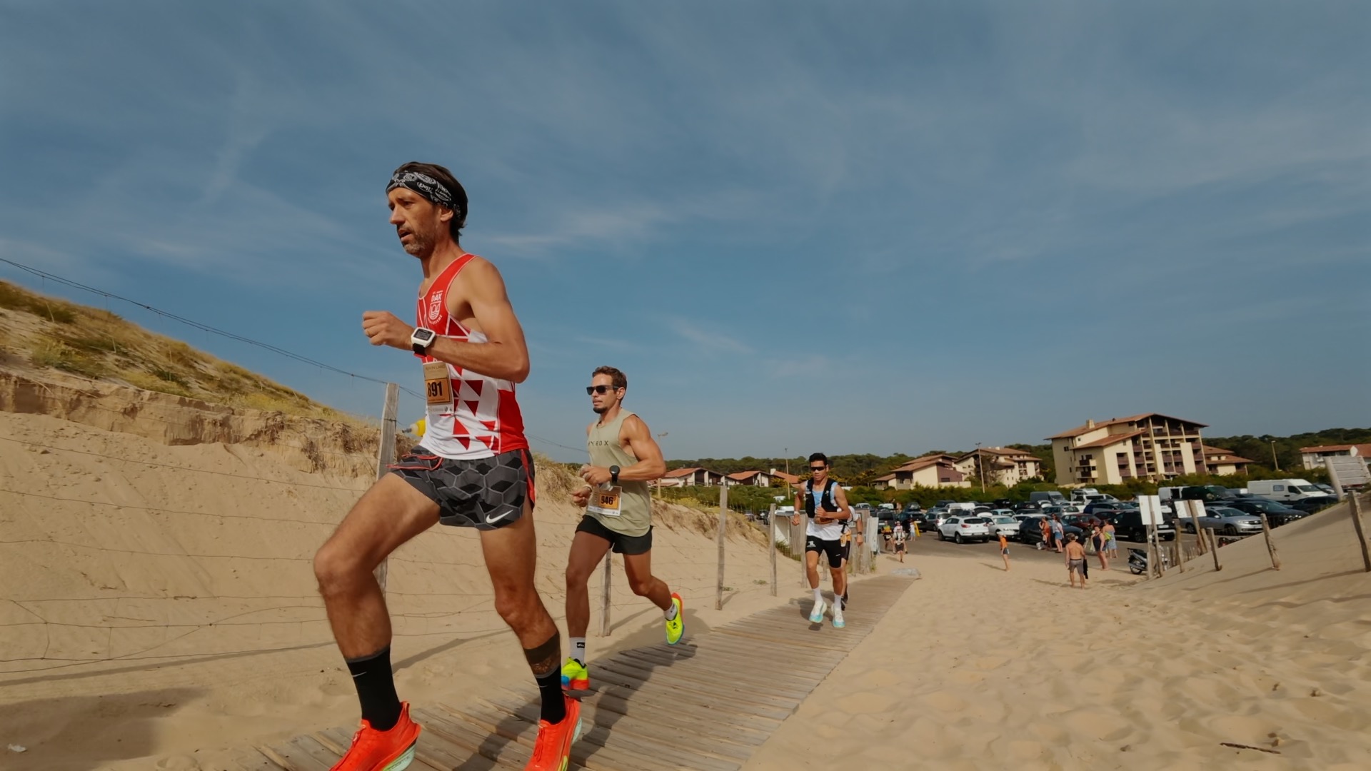 Trois coureurs remontant la passerelle depuis la plage