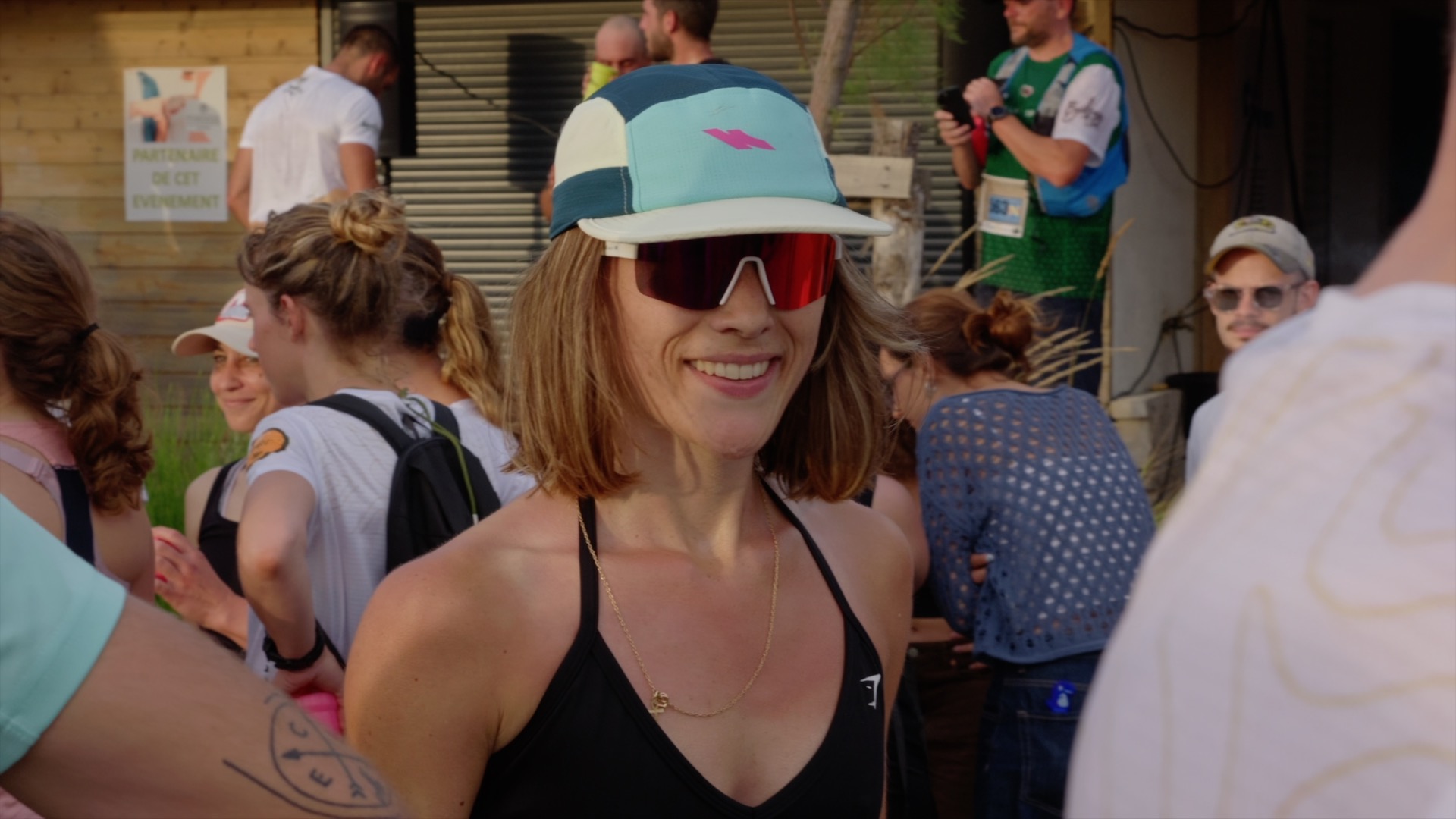 Coureuse souriante casquette Kinetik au village du Penon