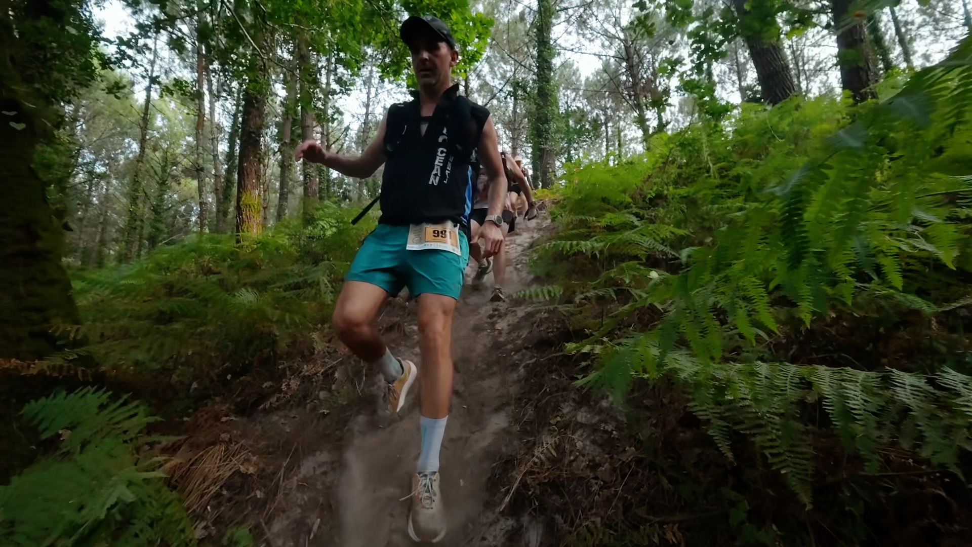 Coureur en short turquoise en montée sur single track sablonneux
