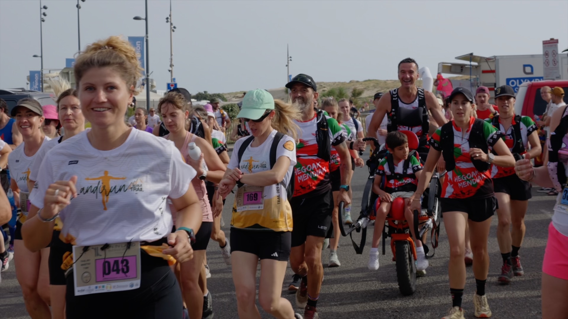 Groupe de coureurs en mouvement avec joëlette Hegoak Mendian