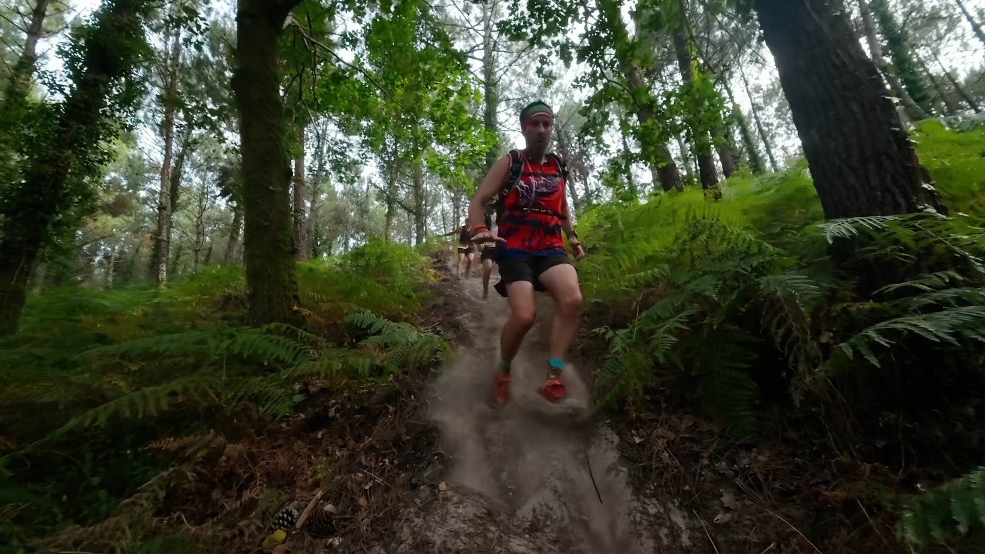 Coureur en maillot rouge dévalant un single track sablonneux