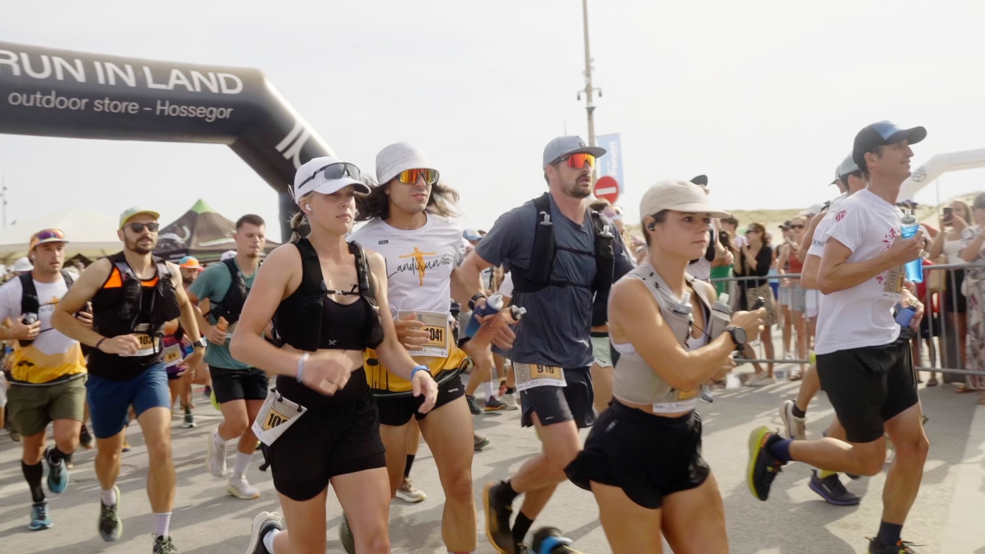 Coureurs en pleine course sous l'arche de départ Run In Land
