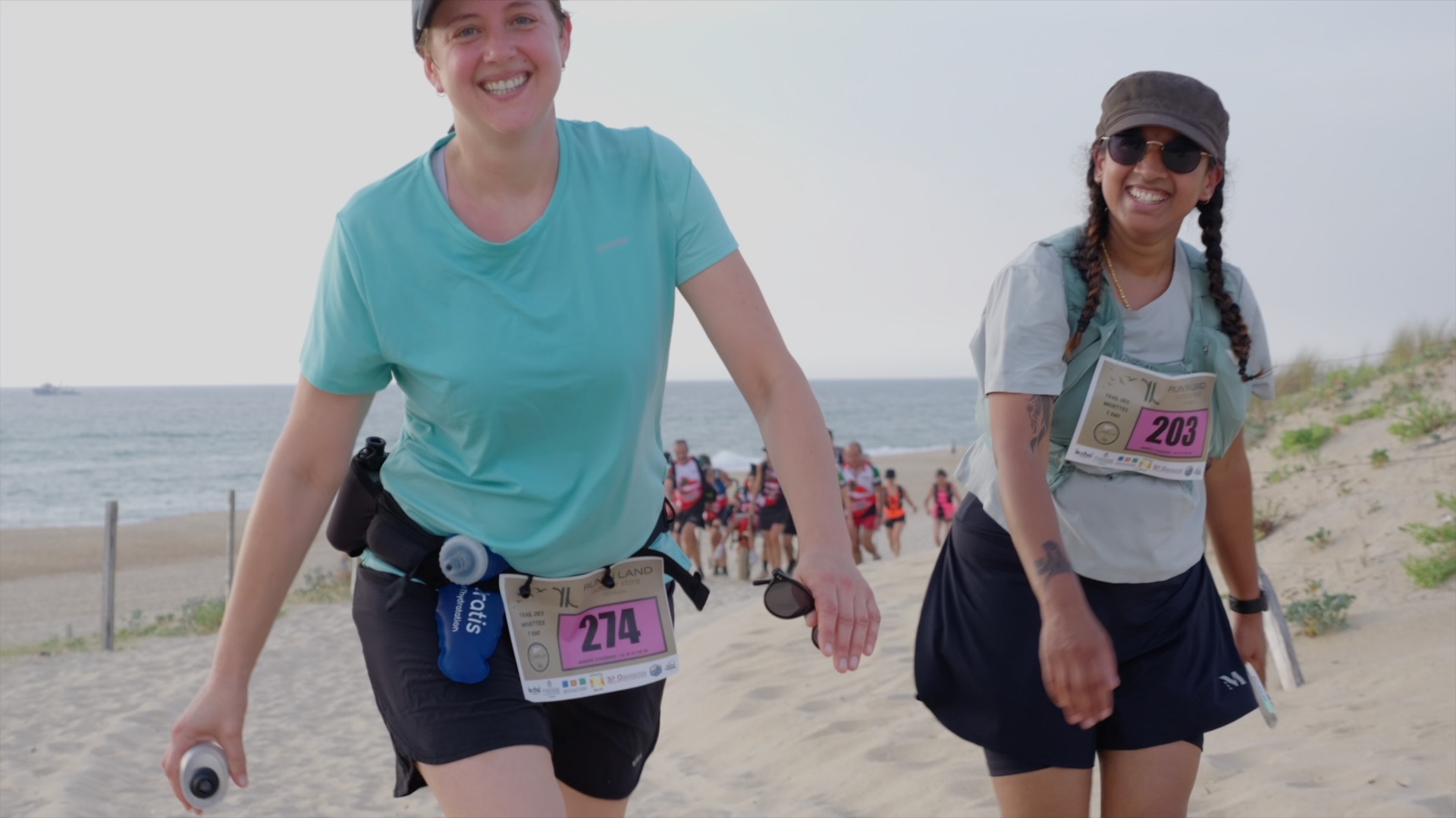 Deux coureuses souriantes sur la dune face à l'océan