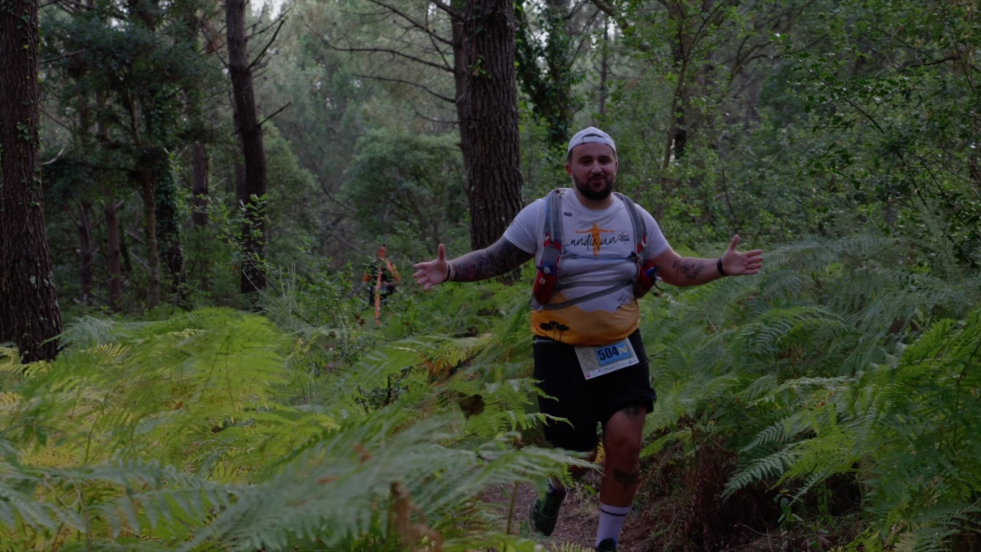 Coureur Landirun bras ouverts dans la forêt de pins