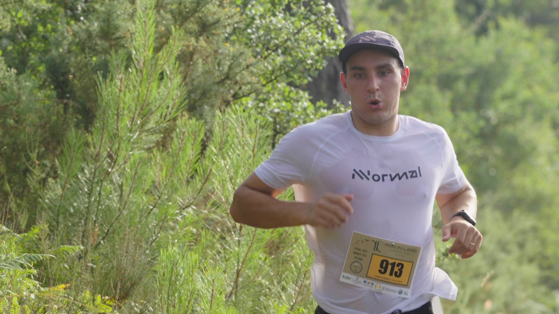 Coureur du 21 km concentré en pleine effort dans la forêt