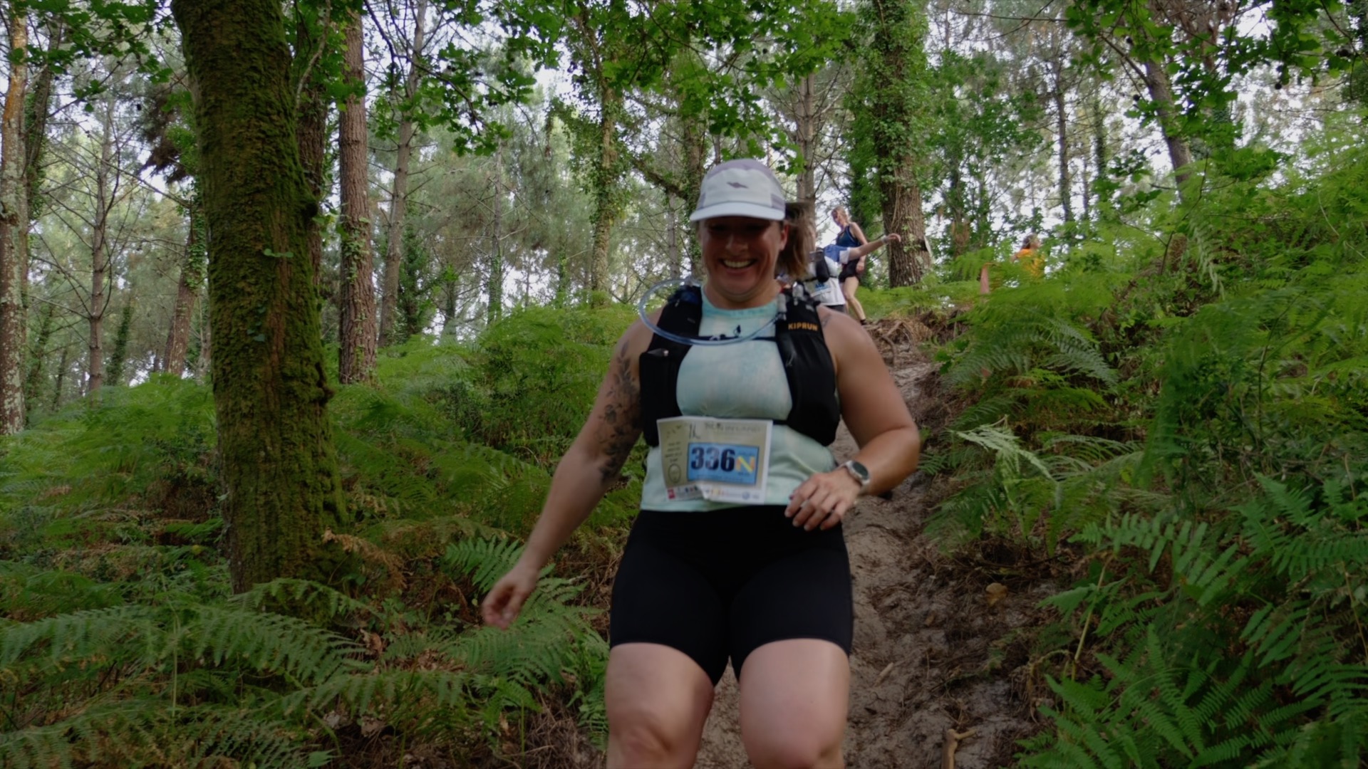 Coureuse souriante dans la montée en sous-bois
