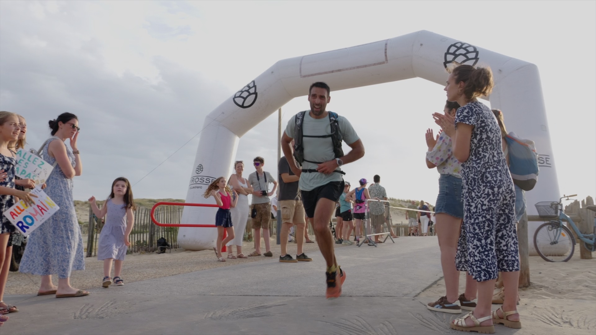 Coureur franchissant l'arche d'arrivée sous les applaudissements