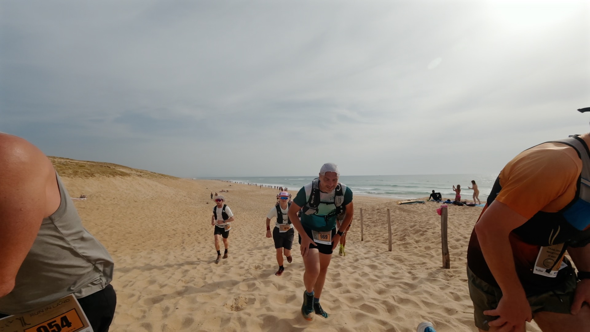 Coureurs franchissant l'accès plage dans le sable